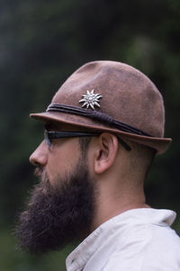 Close-up side view of young man wearing eyeglasses and hat