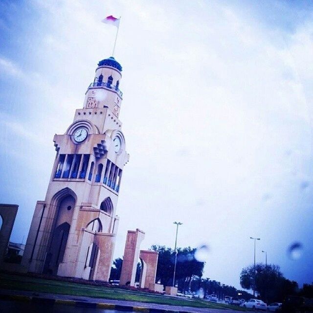 architecture, low angle view, building exterior, built structure, sky, tower, tall - high, cloud - sky, city, day, clock tower, cloud, travel destinations, famous place, flag, blue, capital cities, no people, outdoors, tourism