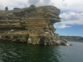 Rock formation in sea against sky