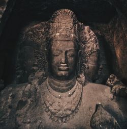 Close-up of old statue against temple