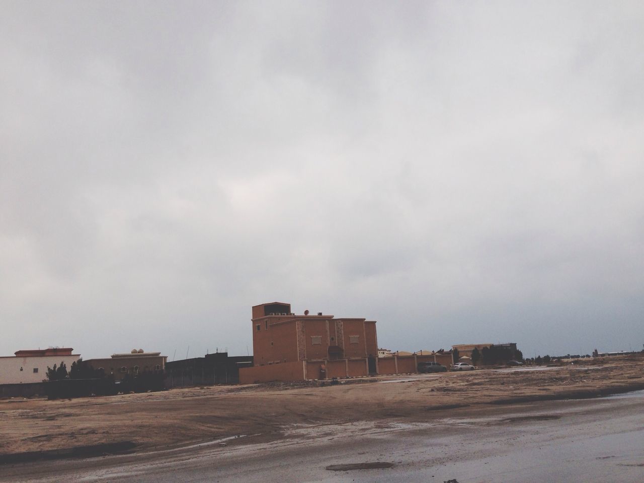 architecture, built structure, building exterior, sky, cloud - sky, house, cloudy, sand, day, abandoned, outdoors, overcast, beach, cloud, no people, road, building, old, residential structure, street