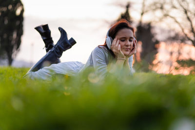 Portrait of woman with arms raised on field