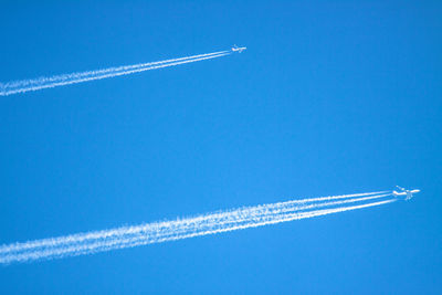 Low angle view of airplanes at airshow against blue sky