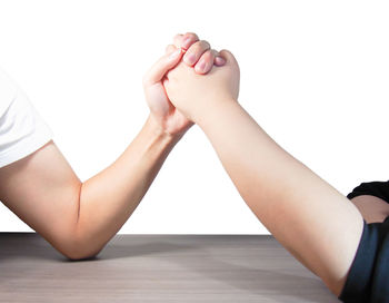 Low section of woman on table against white background