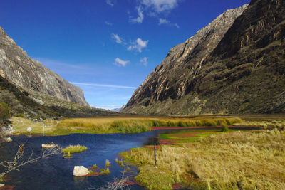 Scenic view of lake and mountains against blue sky