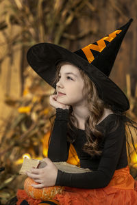 Portrait of young woman wearing hat while standing against sky