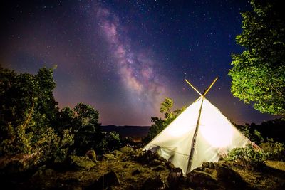 Illuminated tent on countryside landscape