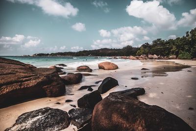 Rocks on beach against sky