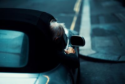 Portrait of man holding car on road