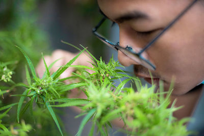 Close-up of young woman holding plant