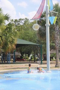 Boy swimming in pool against sky