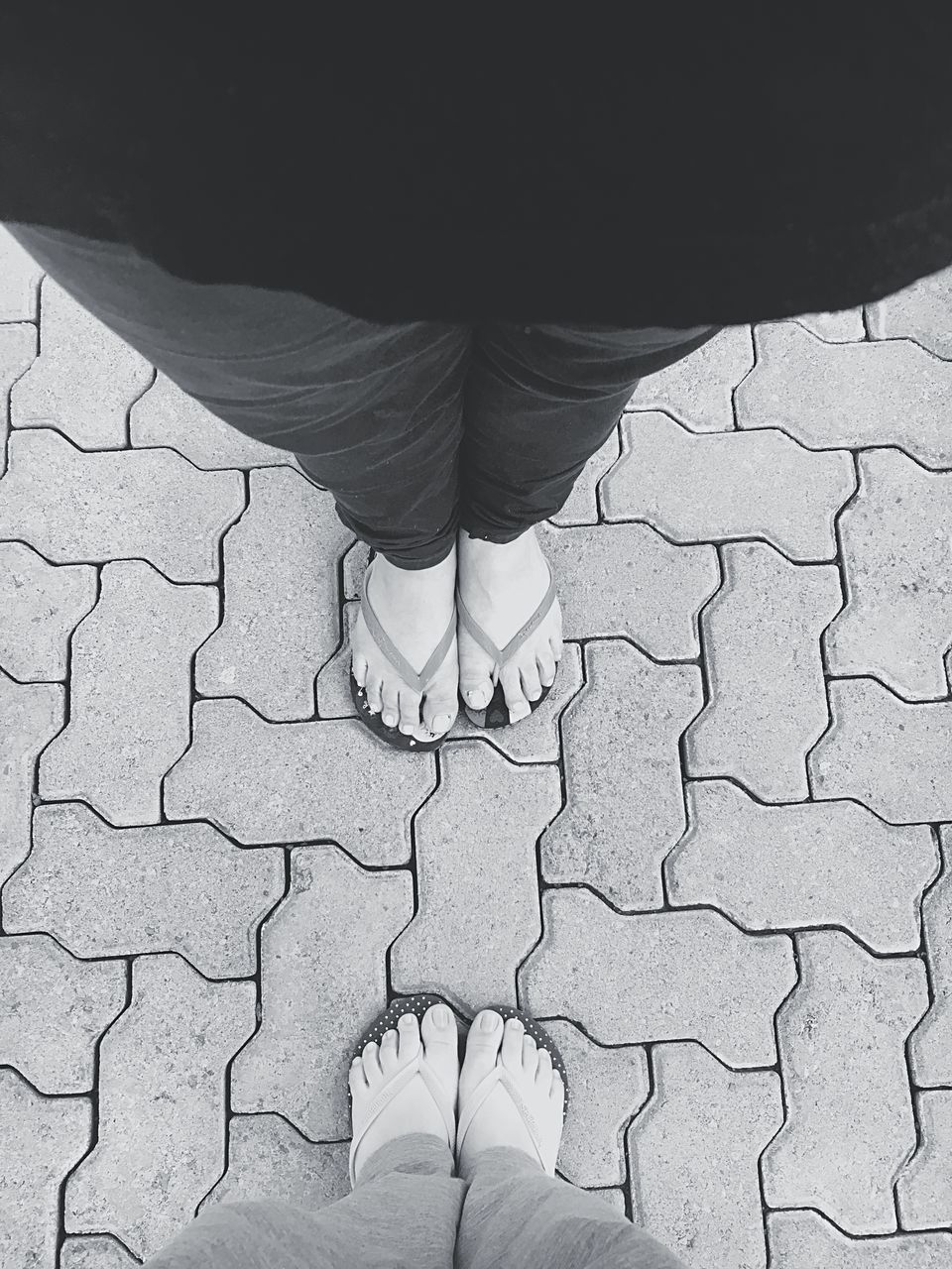 low section, person, personal perspective, human foot, directly below, footpath, paving stone, concrete, outdoors, day