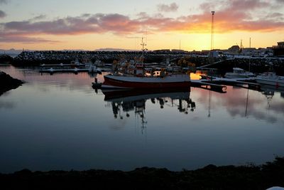 Boats in harbor at sunset