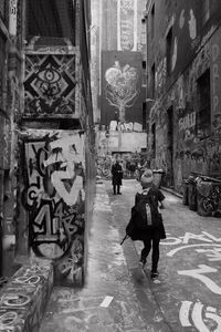 Rear view of people walking on street in city