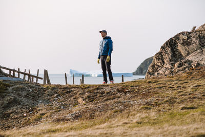 Man with icebergs in the background in spring in twillingate, newfoundland, canada