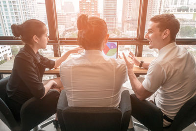 Colleagues using laptop at office