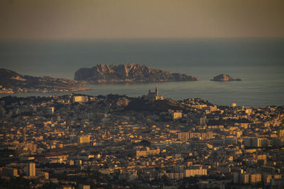 High angle view of townscape by sea against sky