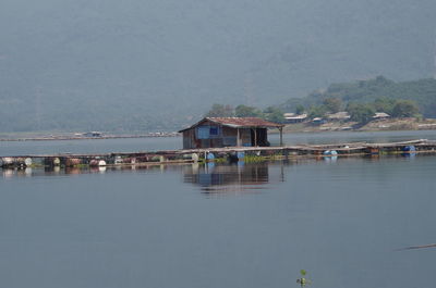 Scenic view of lake by buildings against sky