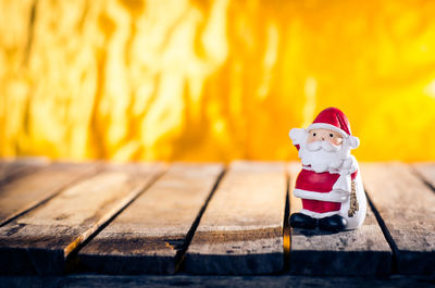 Close-up of santa claus on wooden table against fire