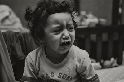 Close-up of girl crying while sitting at home