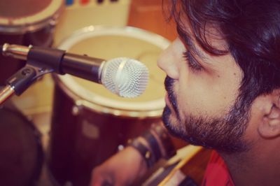 Close-up of man by microphone at recording studio