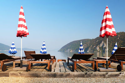 Sun loungers by danube river against clear blue sky