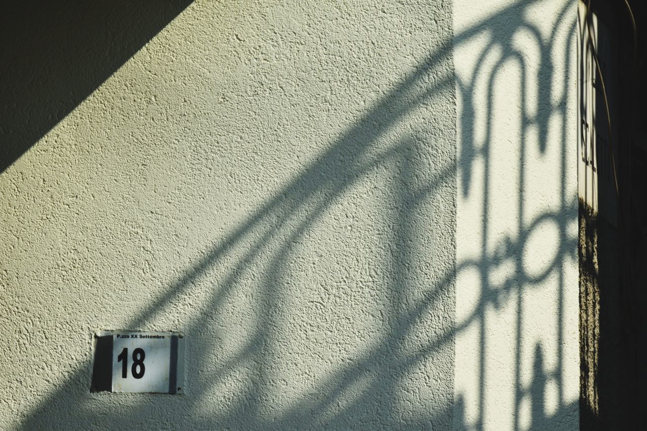 shadow, white, wall - building feature, sunlight, light, black, no people, built structure, line, architecture, wall, day, darkness, communication, sign, building exterior, outdoors