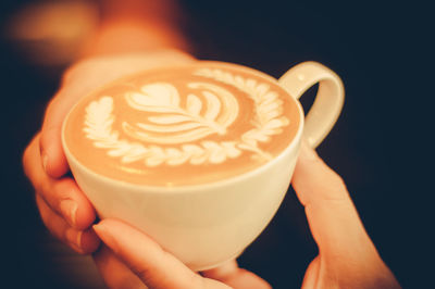 Close-up of hand holding cappuccino