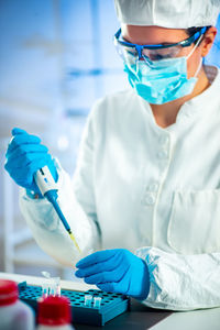 Midsection of scientist performing experiment in laboratory