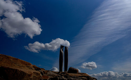 Low angle view of rocks against blue sky