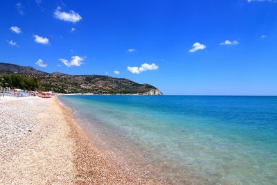 Scenic view of beach against blue sky