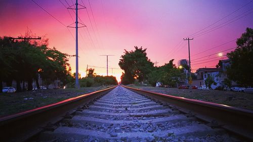 Railway tracks against sky at sunset