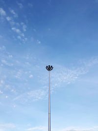 Low angle view of floodlight against blue sky