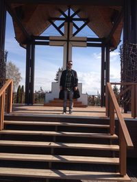 Full length of man atop stairs of outdoor church