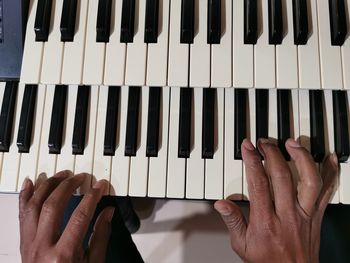 Midsection of person playing piano