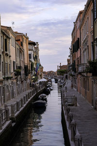Canal amidst buildings in venice against sky