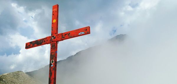 View of cross on mountain against sky