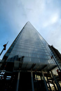 Low angle view of modern building against cloudy sky