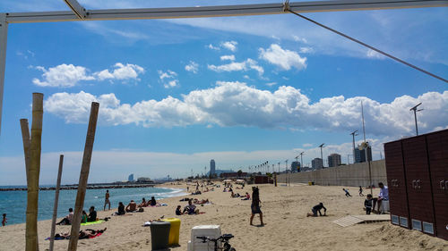 People at beach against sky