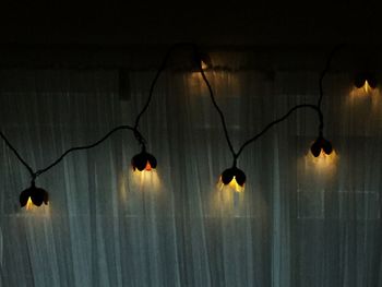 Illuminated decoration hanging on wall at night