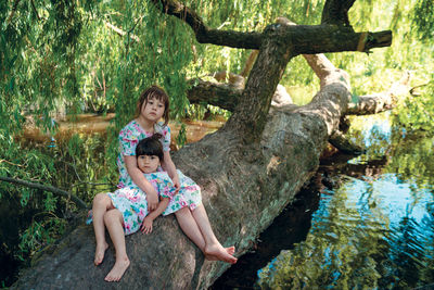 Sisters are sitting on the tree in vondelpark