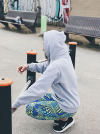 Rear view of man sitting on street