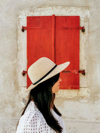 Side view, portrait of a young woman, summer style, hat, wall, window, red