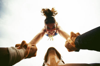 Directly below shot of people holding hands over white background