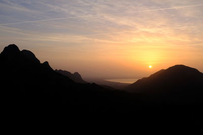 Scenic view of silhouette mountains against sky during sunset