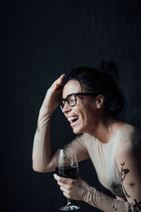 Portrait of smiling young woman drinking glass