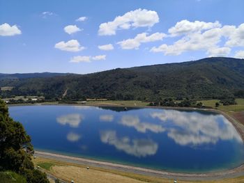 Scenic view of lake and mountains against blue sky