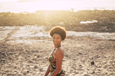 Portrait of smiling young woman standing on beach