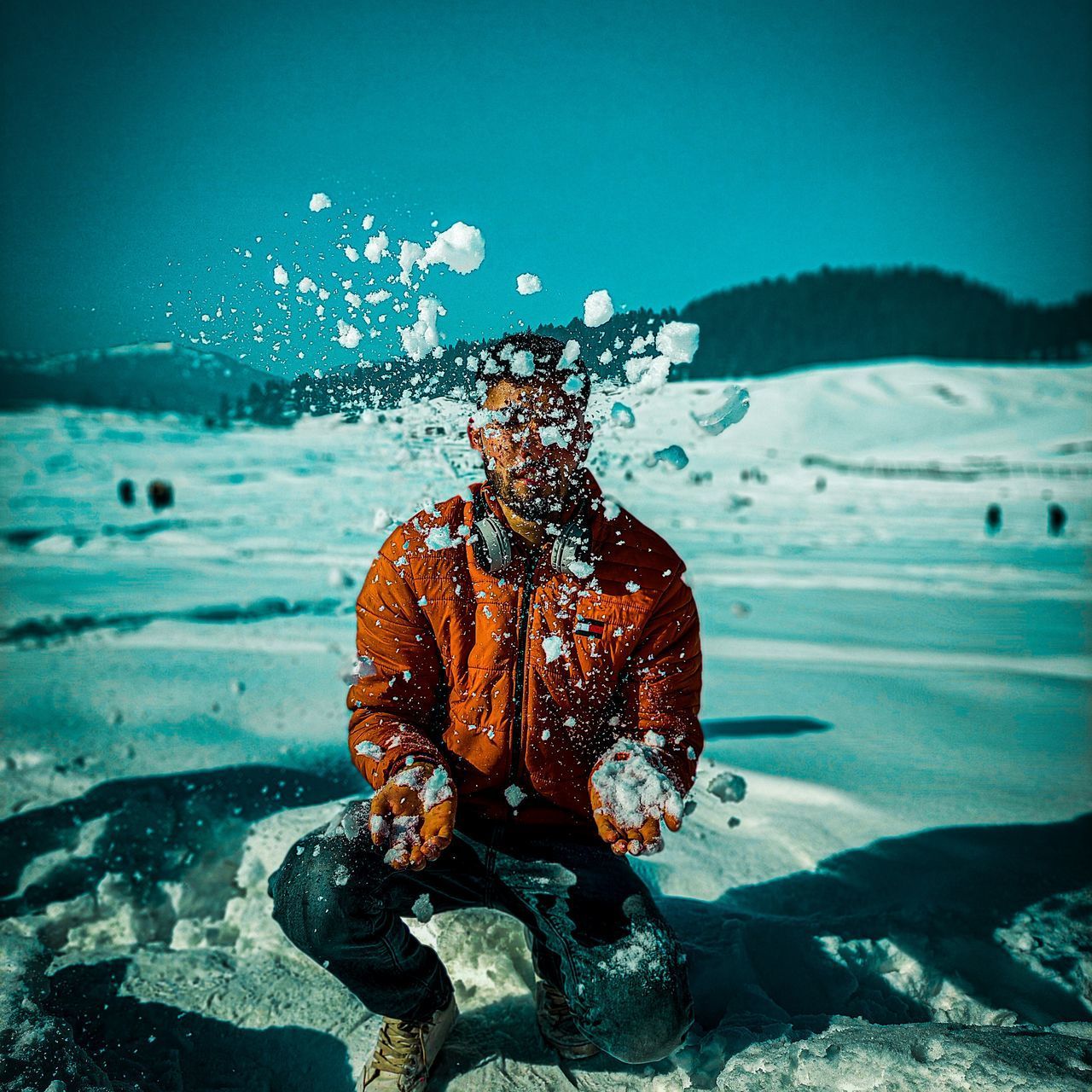 MAN SPLASHING IN SEA AGAINST SKY