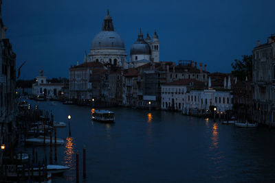 Boats in canal amidst buildings in city